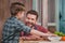 Smiling dad and son cooking meat burgers together