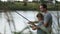 Smiling dad and son fishing and relaxing at pond