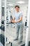 Smiling dark-haired man standing near training device