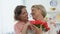 Smiling daughter hugging senior mother holding tulips gift, holiday greetings