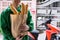 Smiling delivery man hold bakery bag with motorbike