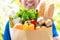 Smiling delivery man holding a grocery bag ready to deliver to the customer