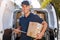 Smiling delivery man loading boxes into his truck