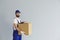 Smiling deliveryman holding cardboard parcel box in hands and looking at camera