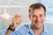 A smiling dentist doctor holds transparent aligners in his hands