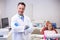 Smiling dentist standing with arms crossed at dental clinic