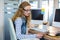 Smiling designer sitting at her desk and looking at colour swatch