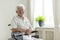 Smiling disabled senior man in a wheelchair alone at home