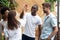 Smiling diverse friends give high five greeting at meeting