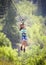 Smiling diverse girl riding a zipline through the forest