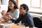 Smiling diverse groupmates have fun eating pizza in office