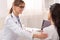 Smiling Doctor Comforting Patient During Medical Appointment In Her Office