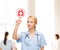 Smiling doctor or nurse pointing to hospital icon