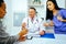 smiling doctor physician and nurse practitioner giving nasal spray to female patient in hospital consultation