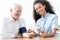 Smiling doctor with stethoscope examining happy elderly man in t