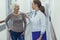 Smiling doctor is talking with female patient with stick