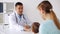 Smiling doctor and woman with baby at clinic