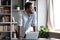 Smiling dreamy African American businessman standing near work desk