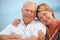 Smiling elderly couple on veranda near seacoast