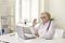 Smiling elderly professional woman doctor greeting patient online during videocall on laptop