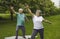 Smiling elderly retired active couple exercising doing morning workout in park