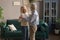Smiling elderly spouses dance waltzing at home