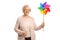 Smiling elderly woman holding a spinning pinwheel