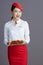 smiling elegant asian female air hostess isolated on grey