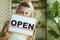 Smiling elegant business owner woman showing welcome sign