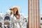 Smiling elegant tourist woman in floral dress talking on phone