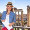 Smiling elegant traveller woman in Rome, Italy with map