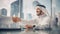 Smiling Emirati Businessman in White Traditional Kandura Sitting in Office with Business Partners.