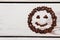 Smiling emoticon made of coffee beans.