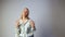 Smiling emotional girl with blond long hair telling something in white studio