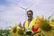 Smiling Engineer With Thumb Up Standing Against Wind Farm
