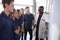 Smiling engineering apprentices gather round whiteboard at a training presentation, close up