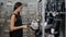 Smiling european woman chooses pans in shop cookware supermarket, happy brunette girl in store