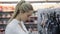 Smiling european woman chooses pans in shop cookware supermarket, happy brunette girl in store