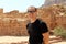 Smiling europian tourist man in sunglasses and black wear in Petra in Jordan during a journey