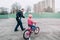 Smiling excited Caucasian father training helping girl daughter to ride bicycle.