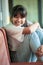 Smiling face of asian teenager sitting wood chair