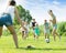 Smiling family with four kids running after ball