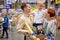 Smiling family hugging, smiling, in love while shopping in supermarket standing In store aisles indoors