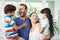 Smiling family with parents carrying children