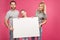 smiling family posing with blank card, isolated