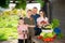 Smiling family standing on backyard with harvested vegetables