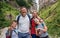 Smiling family standing together on a rugged trail while hiking