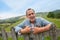 Smiling farmer standing by fence