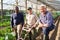 Smiling farmer with tractor cultivator amidst coworkers