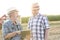 Smiling farmers communicating over digital tablet at farm